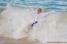Child at play catching a wave body surfing at Waimanalo Beach