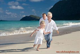 Father with children running on the beach at Waimanalo Beach Oahu Hawaii