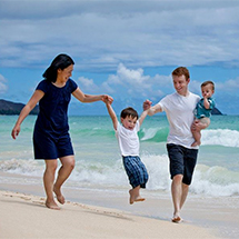 Kailua Family Photography - Family walking on Kailua Beach swinging the son, having a Great time.