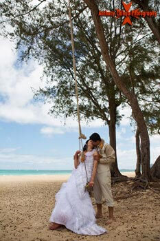 Hawaii Beach Wedding Photography - Bride and Groom on a swing kissing at Waimanalo Beach