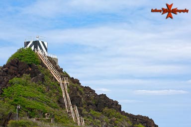 The Pyramid Rock Light currently consists of a light mounted on the roof of a square concrete workhouse, painted with distinctive black & white diagonal stripes. The light guides vessels into Kaneohe Bay & overlooks a recreational beach for the marines.