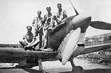 Anthony Caruana, far right sitting on top of the Spitfire engine Circa 1942.